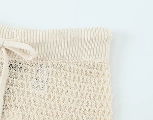 Close-up of cream white chunky knit texture with matching drawstring detail on the set