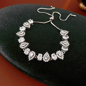 Detail of silver zircon drop bracelet with adjustable drawstring on black velvet base