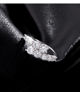 Macro shot of sparkling S925 sterling silver ring with cluster cubic zirconia on black silk