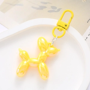Detailed view of a yellow acrylic balloon dog keychain with matching metal clasp
