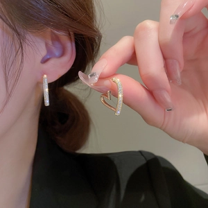 Elegant gold-plated heart and bar drop earrings with zircon stones on model's ear
