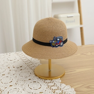 Détail d'un chapeau de paille pour garçon avec broderie de tracteur coloré et ruban