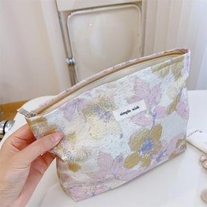 Détail de la trousse de toilette jacquard vintage avec fermeture éclair métallique