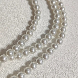 Close-up of white pearls with natural luster and smooth texture on textured surface