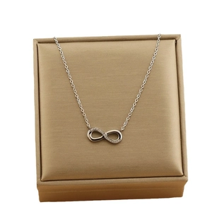 Collana infinito d'argento con piccoli cristalli su scatola oro champagne