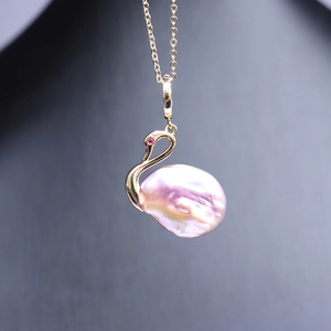 Pendentif cygne doré avec grande perle baroque rose et œil en pierre précieuse rouge