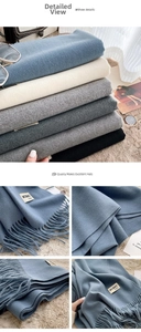 Detailed macro view showing the soft fabric texture and fringe of a cashmere-feel scarf