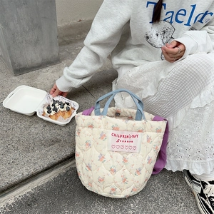 Vue détaillée du sac cabas en coton matelassé crème avec large bandoulière violette