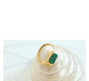 Detail of adjustable gold ring featuring a rectangular green malachite textured stone inlay