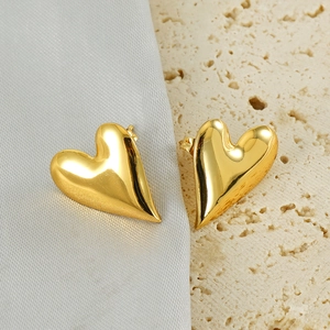 Polished 18k gold plated stainless steel heart stud earrings on decorative stone