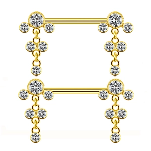 Détail de deux paires de piercings de mamelon dorés avec des pierres précieuses rondes