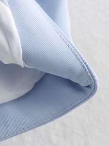 Gros plan du tissu sergé bleu clair et doublure blanche avec coutures soignées
