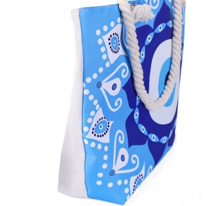 Detail of blue evil eye beach tote with thick cotton rope handle and reinforced eyelets