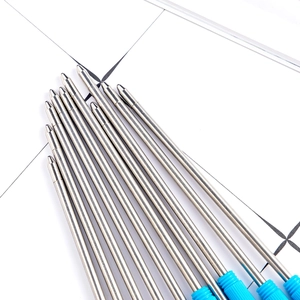 Ten silver metal ballpoint pen refills with blue grips on a white grid mat