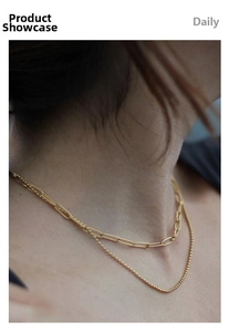 Close-up of layered 18K gold stainless steel paperclip and ball chain necklace on a model
