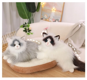 Close-up of realistic ragdoll cat plushies with blue eyes on a soft brown velvet mat