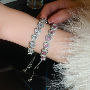 Close-up of heart-cut pink and clear crystal tennis bracelets with adjustable chains
