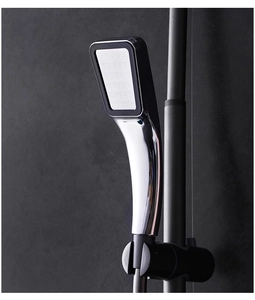 Detail of 300-hole pressurized square shower head with chrome finish and black faceplate