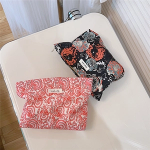 Close-up of vintage floral cotton cosmetic bags with brand label and smooth zipper detail