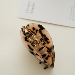 Detailed close-up of large tortoiseshell hair claw clip with leopard pattern and metal spring