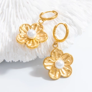 Elegant gold flower earrings with white pearl centers on a textured white background