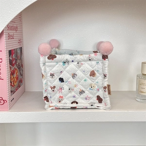 Quilted fabric storage basket with cartoon dog patterns and pink pom-pom corner details
