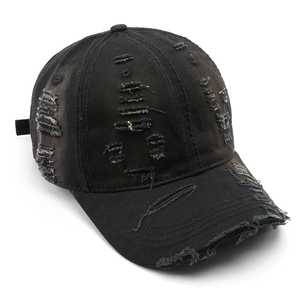 Distressed black cotton baseball cap with vintage frayed holes and sun protection visor
