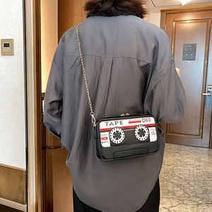 Creative retro cassette tape crossbody bag with gold chain strap on a female model