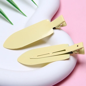 Detail of cream yellow matte hair clips showing front and back clip mechanism