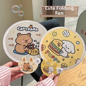 Détail de ventilateurs pliables ronds avec illustrations de Capybara et chiot