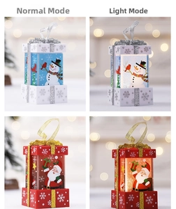 Close-up of glowing Christmas gift box night light with Santa and Snowman designs