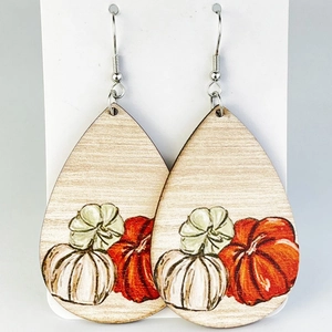 Detail of teardrop wooden earrings featuring colorful autumn pumpkin patterns on white cards