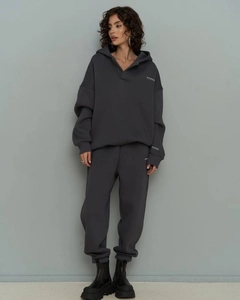 Detail of grey oversized hoodie set with white logo and high-waist joggers texture