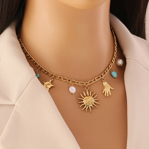 Détail du collier doré avec visage de soleil, main de Hamsa, perles et turquoises