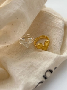Dettaglio di anelli a cuore regolabili in oro e argento con texture vintage martellata
