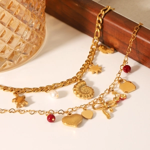 Gold charm bracelet with sea turtle, heart and pearl pendants on elegant link chain
