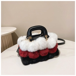 Detail of plush tricolor faux fur handbag with leather handle and golden hardware