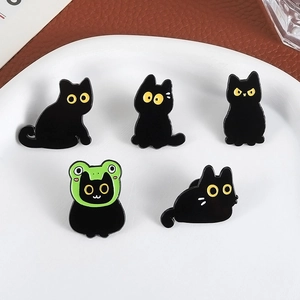 Five cute black cat enamel pins set featuring a cat in a green frog hat on white plate