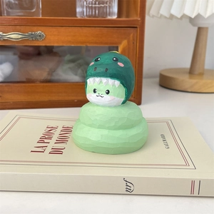 Figurine dinosaure verte créative sur un livre dans un bureau chaleureux