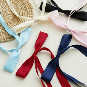 Elegant satin bow hair clips with long tassels in multiple colors on a neutral background