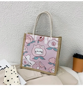 Detail of jute tote bag with cute cartoon peach cat print and soft cotton rope handle