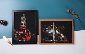 Detail of framed city night scrap art with black and wood frames on decorative background