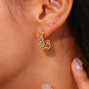 Vue détaillée de boucles d'oreilles créoles dorées en C avec motif résille et strass