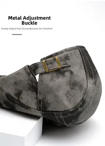 Close-up of adjustable bronze metal buckle on a grey textured newsboy hat
