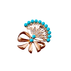Vintage fan-shaped bow brooch with sky blue beads and sparkling crystals in gold plating