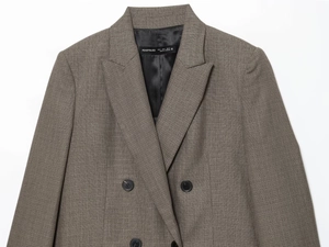 Detailed view of brown suit blazer showing lapels, shoulder pads, and double-breasted buttons