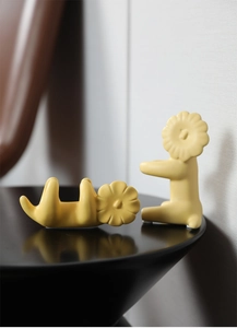 Detail of yellow ceramic lion figurines with creative petal mane in a minimalist home setting