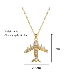 Detailed view of gold airplane pendant with crystal pavé and product dimensions