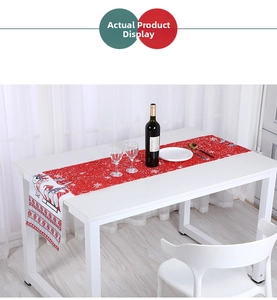 Close-up of red Christmas table runner with white snowflakes and festive reindeer design