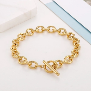 Close-up of golden T-bar toggle clasp and polished circular links on a stylish chain bracelet
